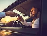Happy traveler meeting a professional driver after they pre-book airport transfer services.